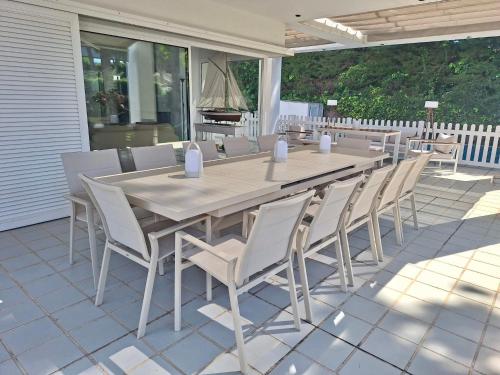 a wooden table and chairs on a patio at Villa Pinares de Roche - Piscina privada - Playa a 6 min in Roche