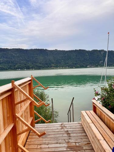 a wooden deck with a view of a lake at Lakeside Garden Ossiacher See in Sattendorf