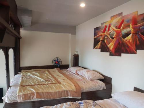 a bedroom with two beds and a painting on the wall at Saadis cottage in Bhurban