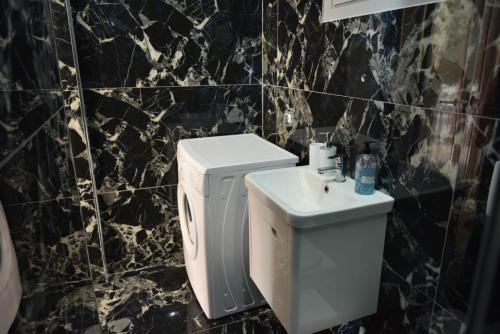 a black and white bathroom with a sink and a toilet at Residence Rudaj in Vlorë