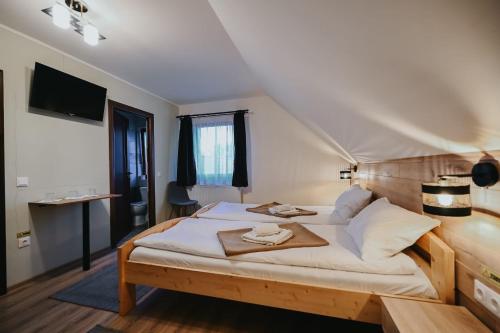 a bedroom with a large bed with a wooden headboard at Grádics Panzió in Siculeni