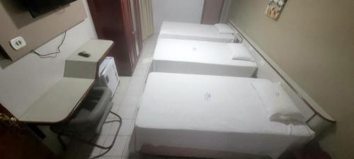 a row of beds in a room at SERRA AZUL PLAZA HOTEL in Barra do Garças