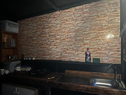 a kitchen with a brick wall and a sink at Kroom cabins in Bâne
