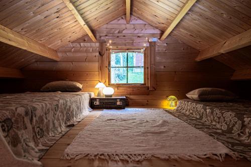 two beds in a wooden room with a window at Fjord View Off-Grid Cabin in Ålesund