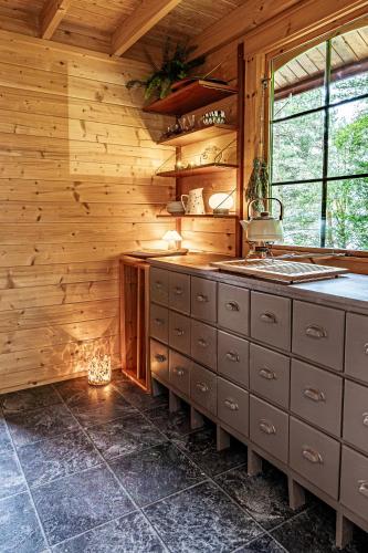 a kitchen with wooden walls and a counter with a sink at Fjord View Off-Grid Cabin in Ålesund