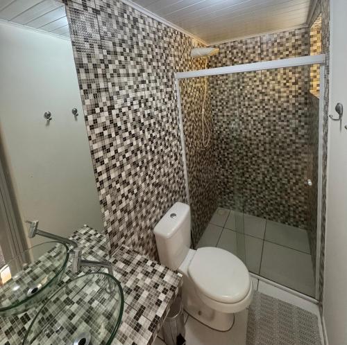 a bathroom with a toilet and a sink and a shower at Chalé em Maresias - Quintal Privativo - Pet Friendly 4 Hóspedes in Maresias