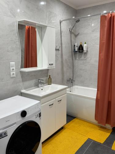 a bathroom with a sink and a washing machine at Basarab Residence Urban Comfort Apartment in Râșcani in Chişinău
