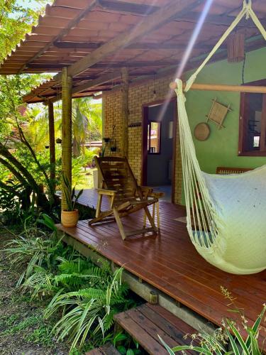 a hammock on the deck of a house at Casa Raiz 1 Moreré - A 3min da praia in Moreré