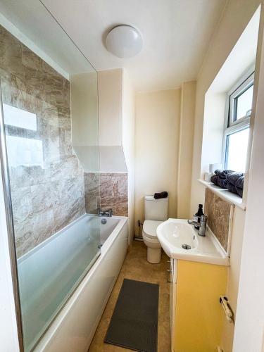 a bathroom with a tub and a toilet and a sink at The Lodge Mews in Shaw Mills