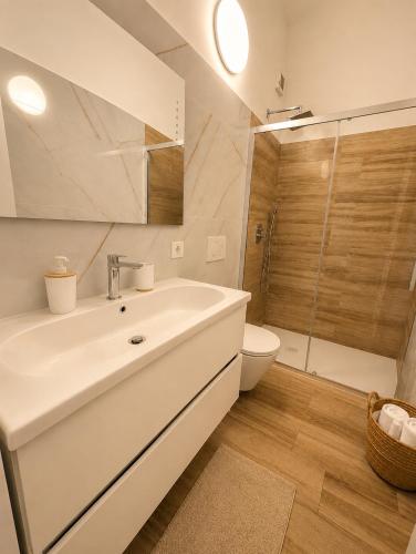 a white bathroom with a sink and a toilet at Domus Regina Sforza in Capurso