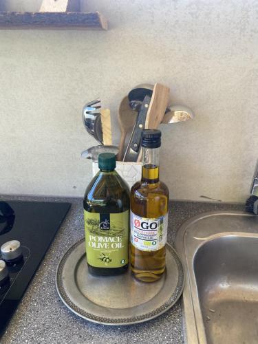 two bottles of oil sitting on a kitchen sink at Anno 1782 Unique Romantic Glamping at the Manors Historic Barn in Arnager
