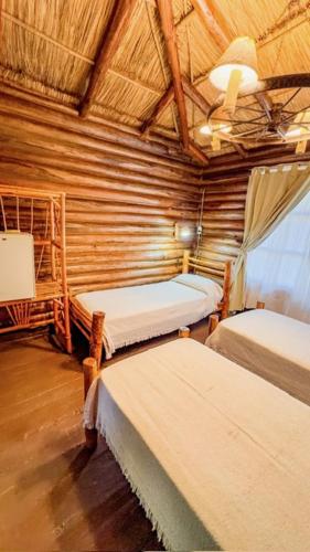 a room with three beds and a ceiling at Habitacion en Cabañas Bella vista in Bella Vista