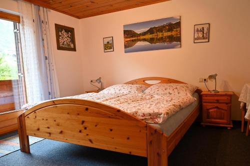 a bedroom with a wooden bed and a window at Haus Helene in Sankt Gallenkirch