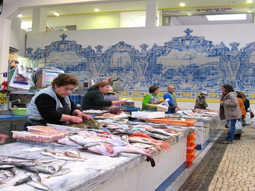 um grupo de pessoas num mercado que vende peixe em Sea and Marina view Apartment em Setúbal