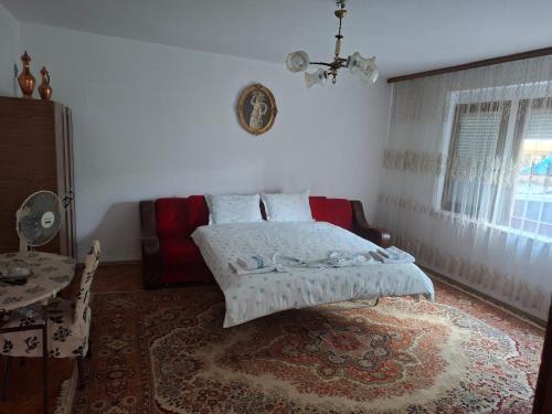 a bedroom with a bed and a couch and a table at Roof - Holiday Home in Gjakove
