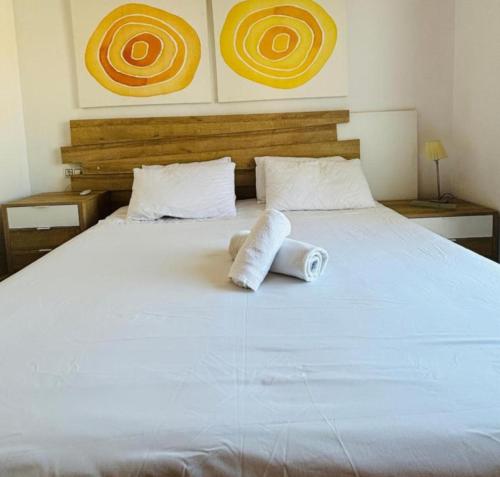 a white bed with two rolled towels on it at Casa Kave Euro Roda-Los Alcazares in Los Alcázares