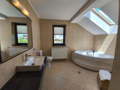 a large bathroom with a large tub and a sink at Pensiunea Toscana in Braşov