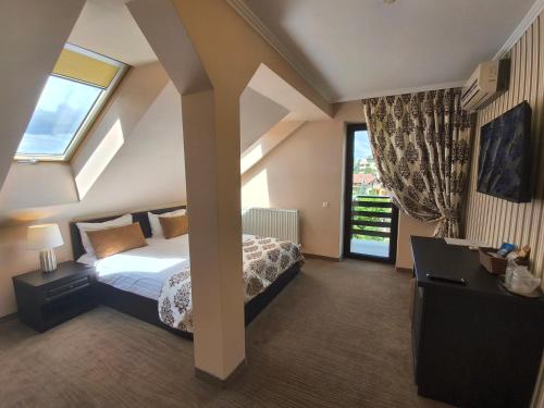 a bedroom with a bed and a large window at Pensiunea Toscana in Braşov