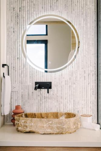 a bathroom with a stone tub and a mirror at Lakay Monteverde with Heated Pool, Golf Cart and Breakfast in Monteverde Costa Rica