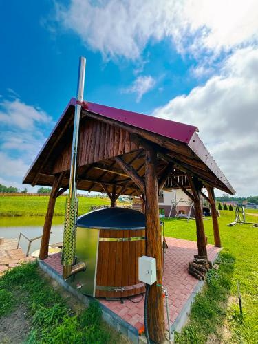 a gazebo with a hot tub in a field at Domek nad Oczkiem Wodnym in Giżycko