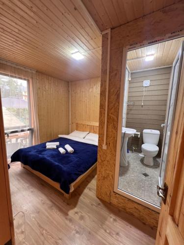 a room with a bed and a bathroom with a toilet at Alpine Lodge Bakhmaro in Chʼkhakoura