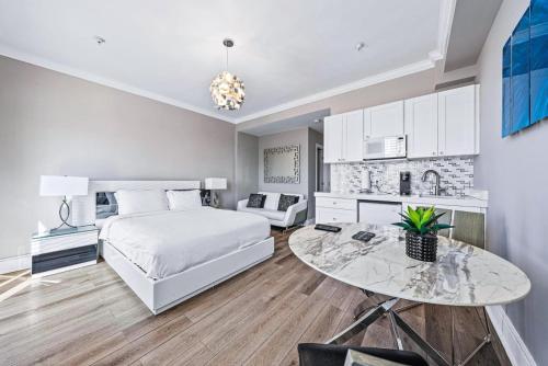 a bedroom with a bed and a table and a kitchen at 1BR Retreat with Private Terrace in Palm Beach