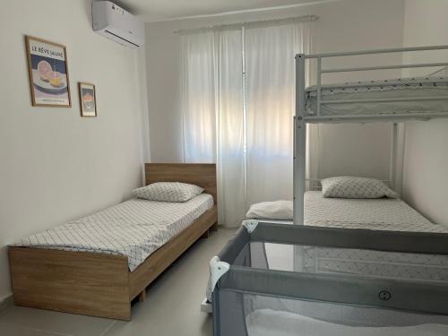 two beds in a room with a bunk bed at FAME Apartment - Permet in Përmet