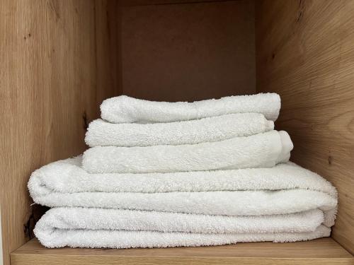 a stack of white towels sitting on a shelf at FAME Apartment - Permet in Përmet