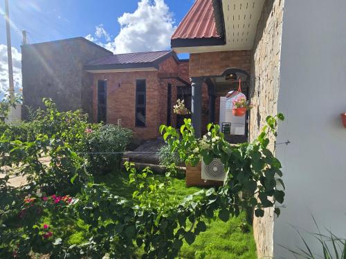a brick house with plants in front of it at Verified Stone House in Dodoma