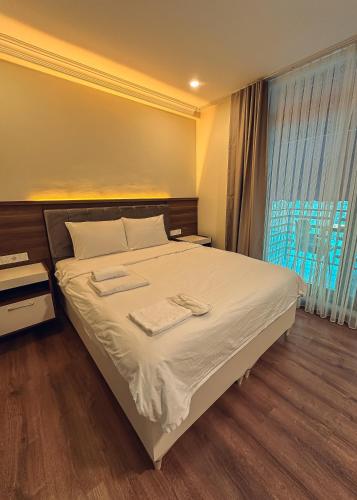 a bedroom with a bed with two towels on it at Çamra Otel in Armutlu