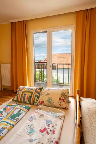 a bedroom with a bed and a large window at Gästehaus Elfriede in Mörbisch am See