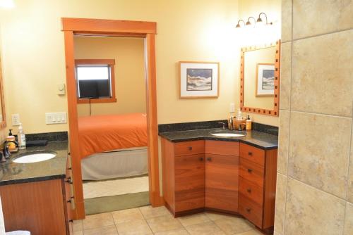a bathroom with two sinks and a bedroom with a bed at Corbin B&B in Corvallis