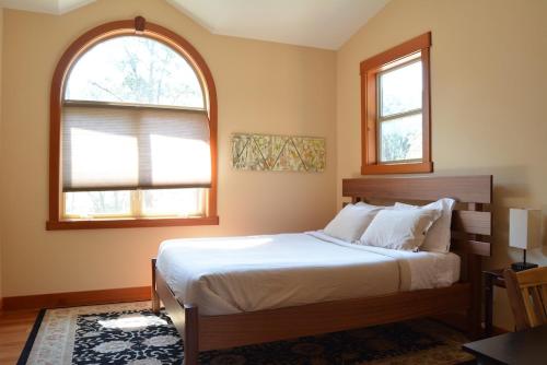 a bedroom with a large bed and two windows at Corbin B&B in Corvallis
