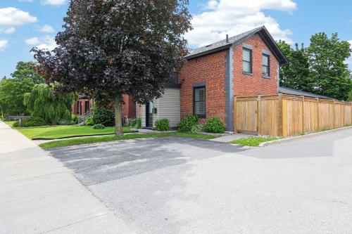 a red brick house with a wooden fence at The 1883 Century Flat Suite in Collingwood