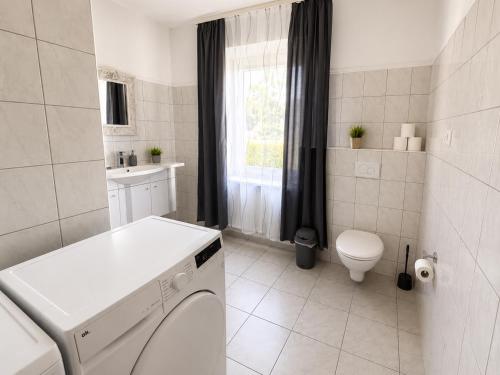 a white bathroom with a toilet and a sink at Pension Reiter in Blomberg