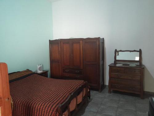 a bedroom with a bed and a dresser and a mirror at Graciela in Villa Las Rosas