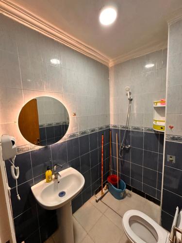 a bathroom with a sink and a mirror and a toilet at Appartement Nadin in Martil