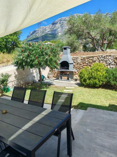 a table and chairs with a fireplace in a yard at Jacuzzi House Kaštela - Parking - Playground in Kaštela