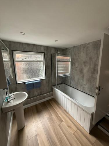 ein Badezimmer mit Badewanne und Waschbecken in der Unterkunft Sullys in Hastings