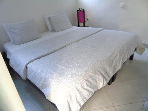 a large white bed sitting in a room at La Maison Nature Relax, Explore, Unwind in Asguine