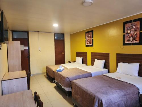 a hotel room with two beds and a tv at Hotel Palace in Huancayo