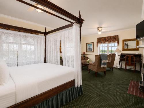 a bedroom with a canopy bed and a dining room at Lafayette Hotel Marietta in Marietta