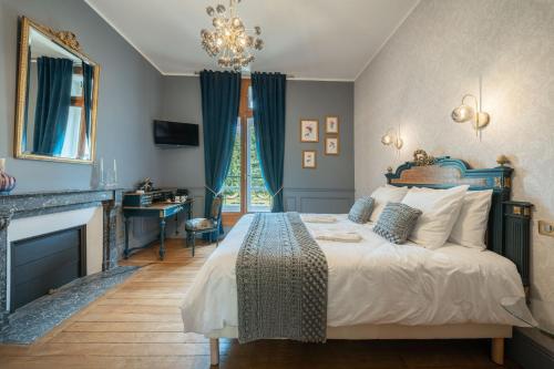 a bedroom with a bed and a desk and a fireplace at Domaine de La Bourse in Vérigny