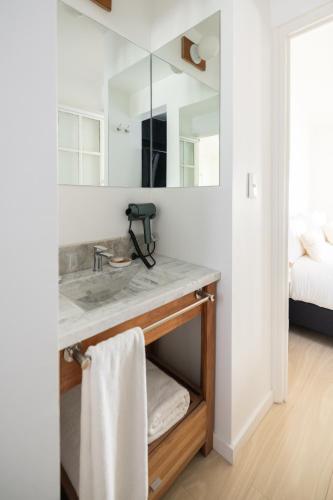 a bathroom with a sink and a mirror at Acassuso Suites in Acassuso