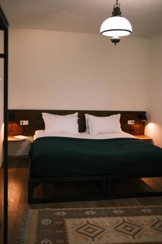 a bedroom with a large bed with a green blanket at Togonidze's Wine Cellar in Telavi