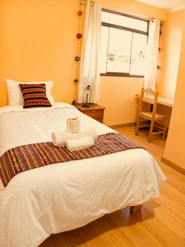 a bedroom with a bed with two towels on it at Imasmari Wasi in Pisac