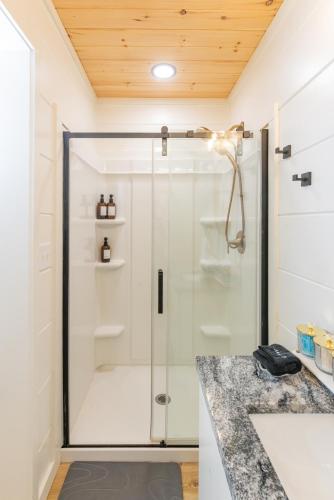 a shower with a glass door in a bathroom at S'more Memories-Cold Plunge, Sauna, Hot Tub Wellness Retreat in Campton