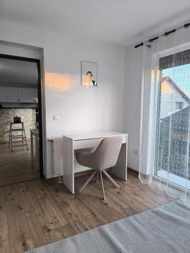 a white desk and a chair in a room at Aero Comfort Apartment in Cluj-Napoca