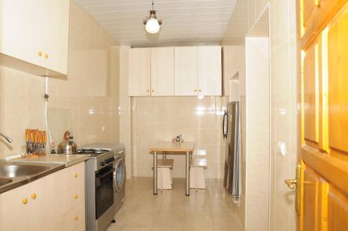 a kitchen with white cabinets and a table in it at Grimis Villa in Borjomi