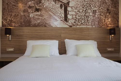 a bedroom with a bed with two pillows at Hotel Luna in Međugorje